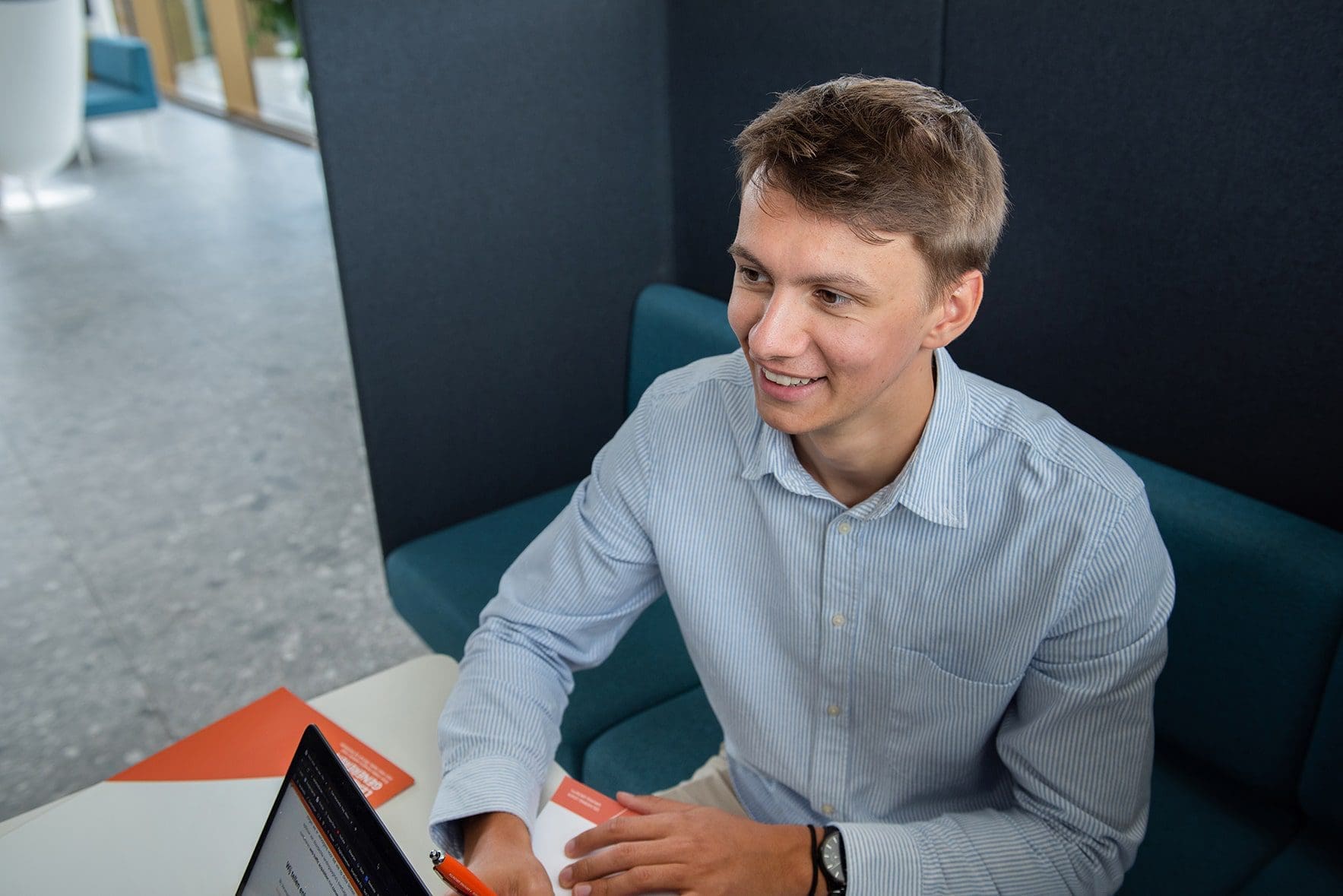 Glimlachend teamlid van Varamedia dat een certificaat van prestatie vasthoudt in een professionele kantooromgeving | Varamedia