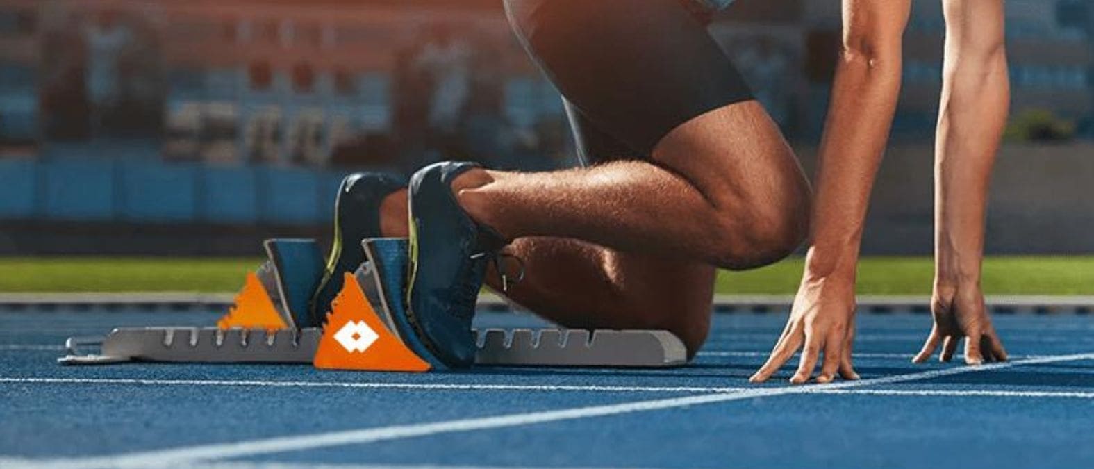 Kwalitatieve leads Atleet in startblokken klaar voor sprint op blauwe atletiekbaan