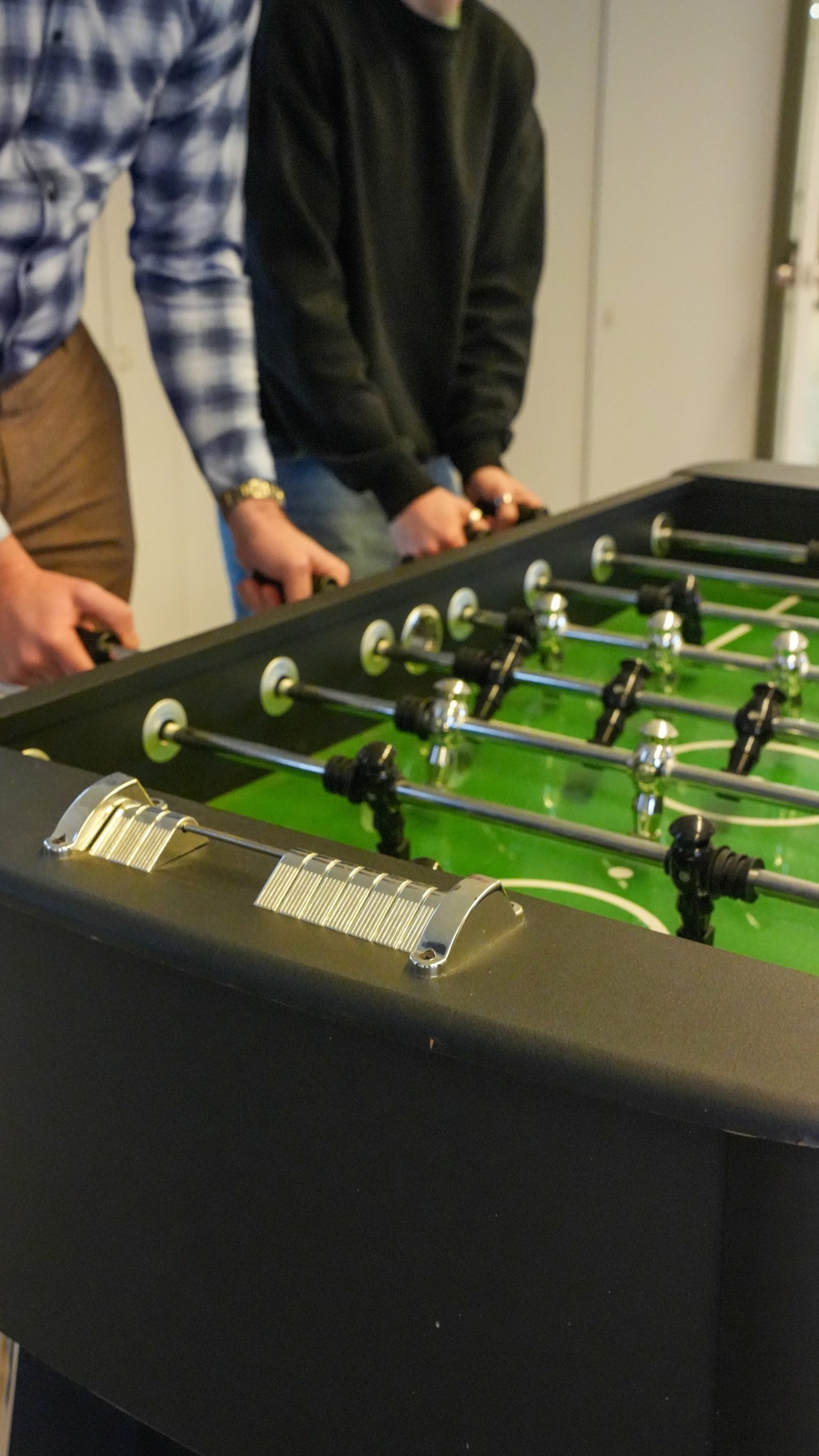Twee collega's spelen tafelvoetbal op kantoor