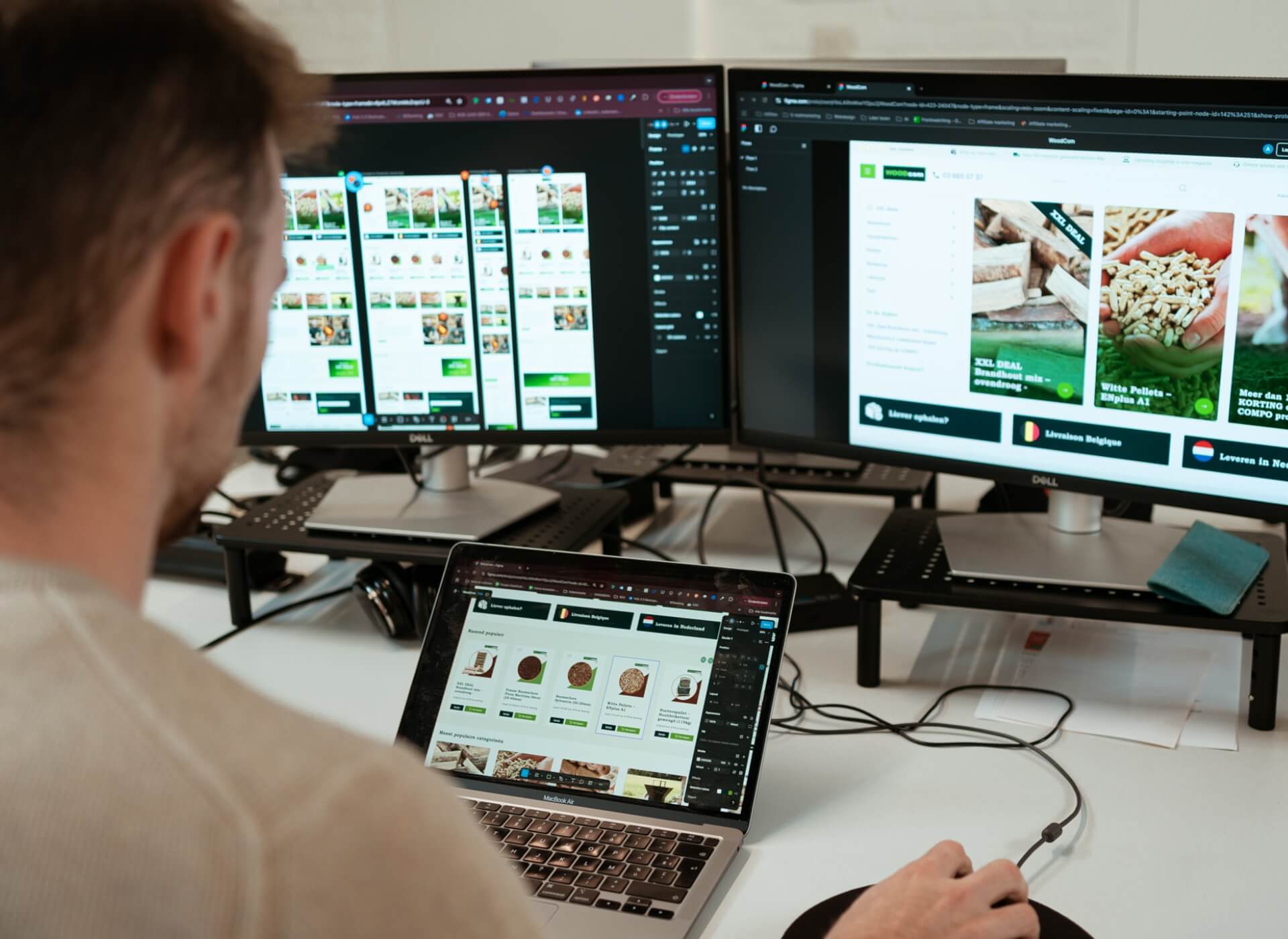 Man bekijkt groen webshopdesign op twee monitors en laptop