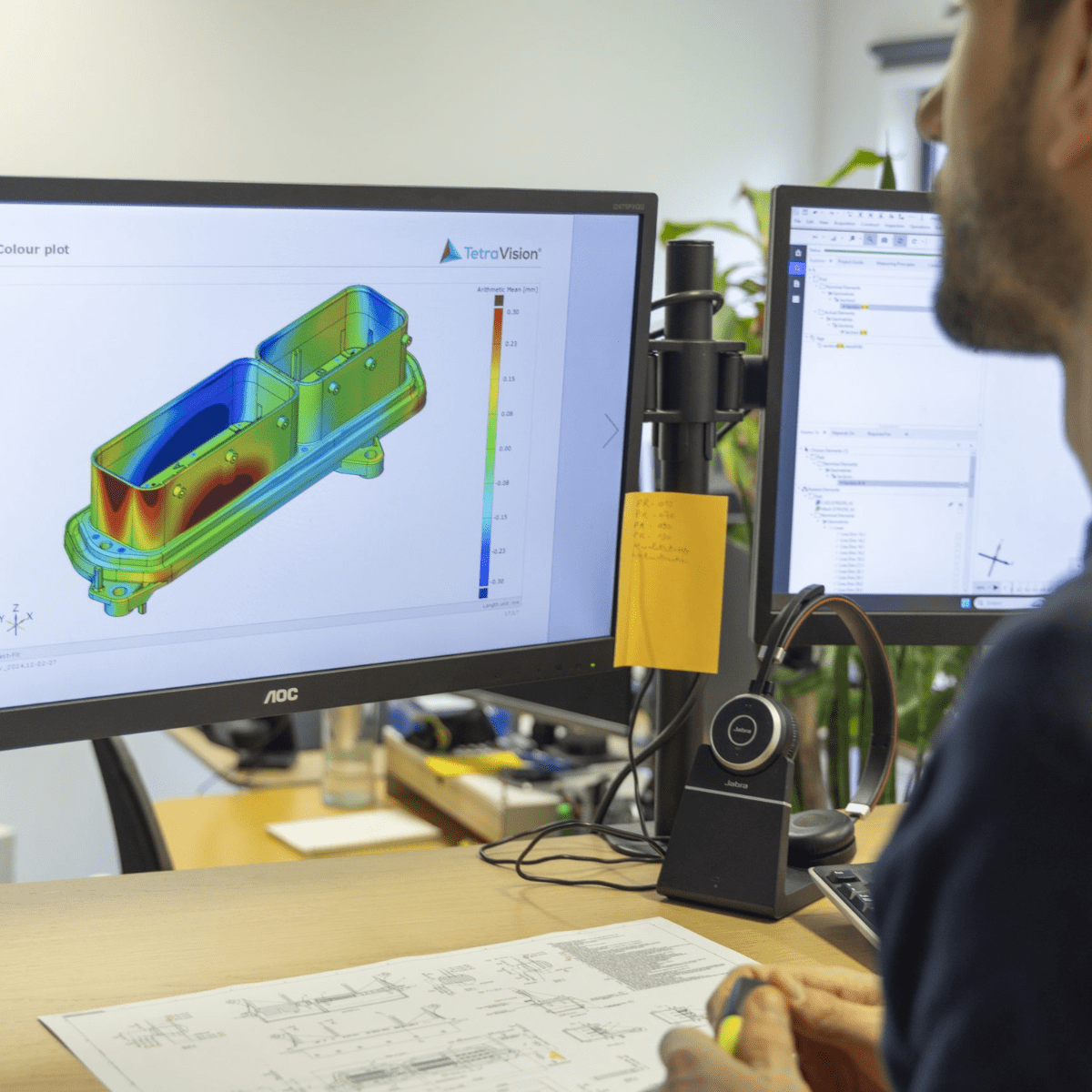Ingenieur bekijkt 3D simulatiesoftware op twee monitoren