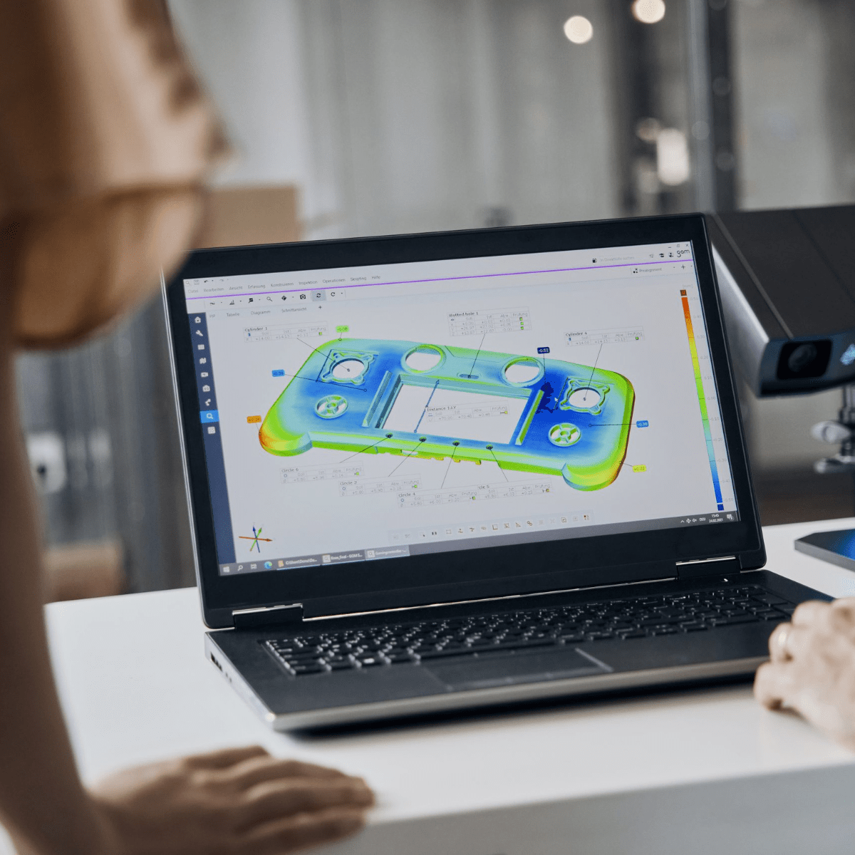 Laptop met kleurrijke CAD-simulatie van een gamecontroller op scherm