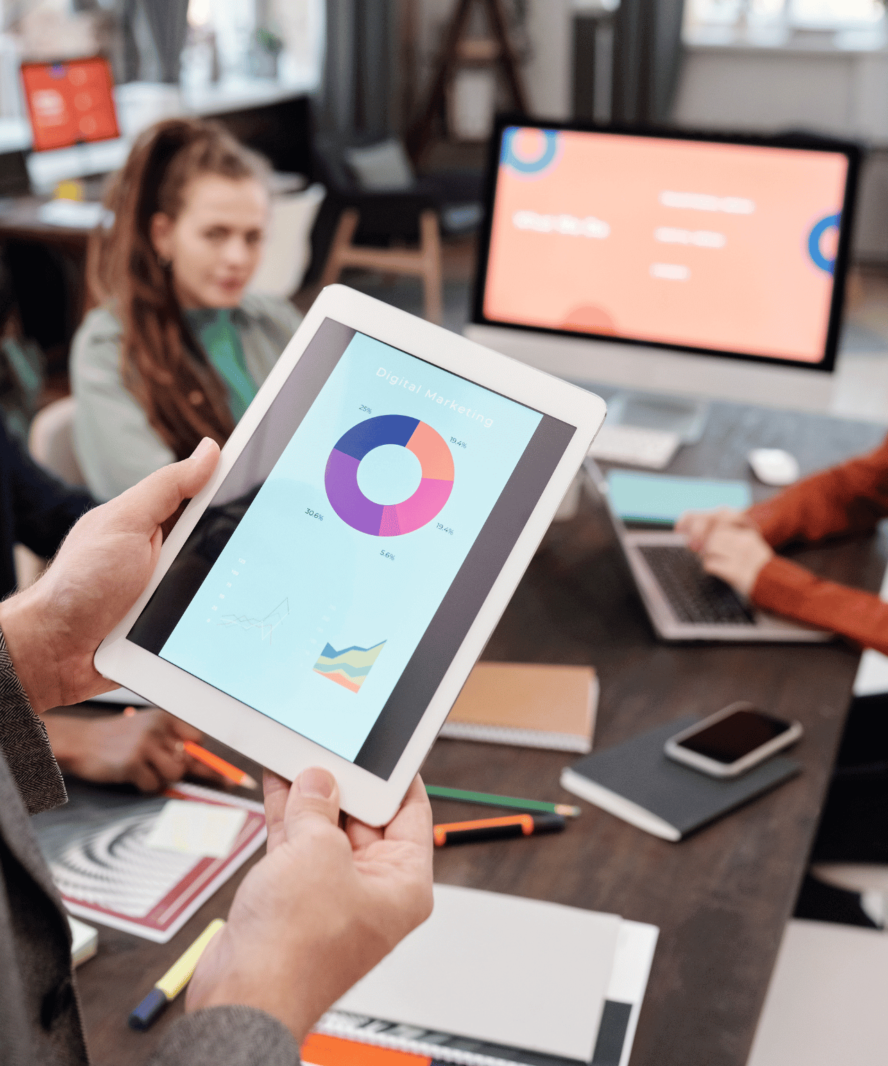 Handen houden tablet met cirkeldiagram vast in modern marketingkantoor