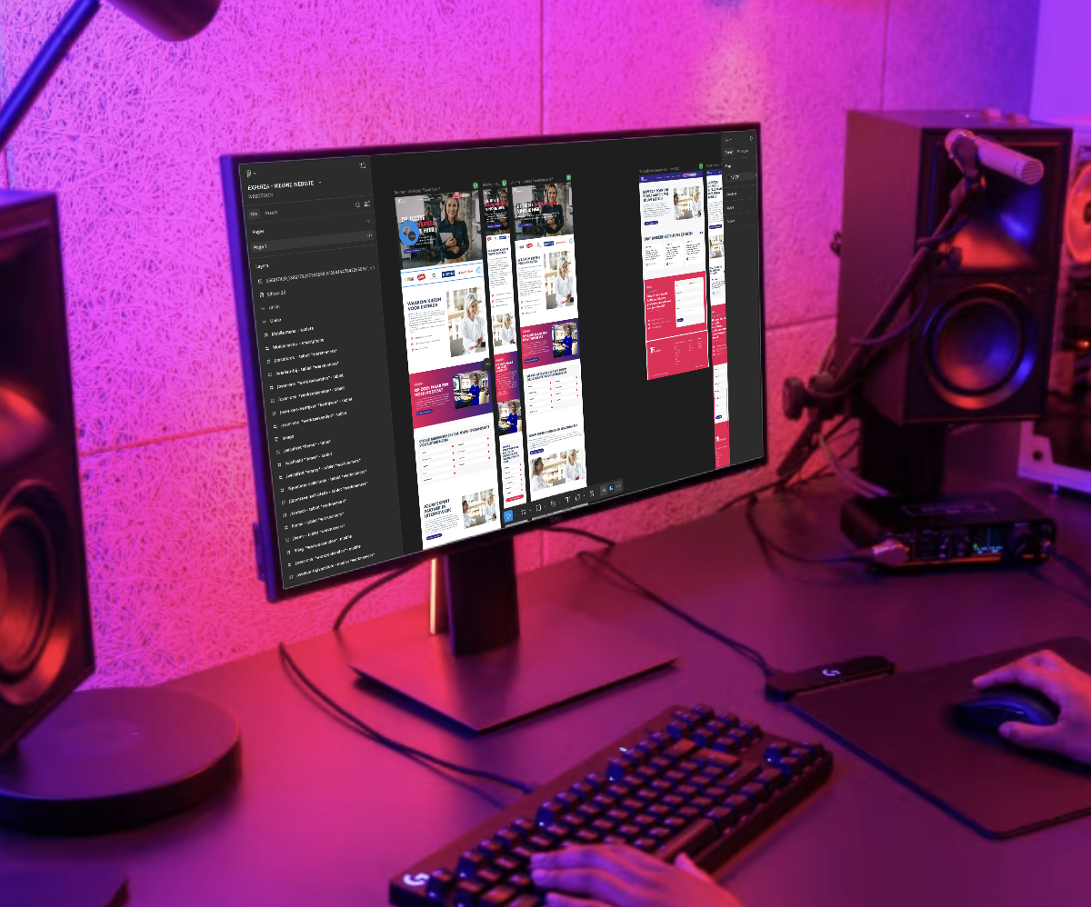 Computerscherm met website-ontwerpen in paars verlichte werkruimte